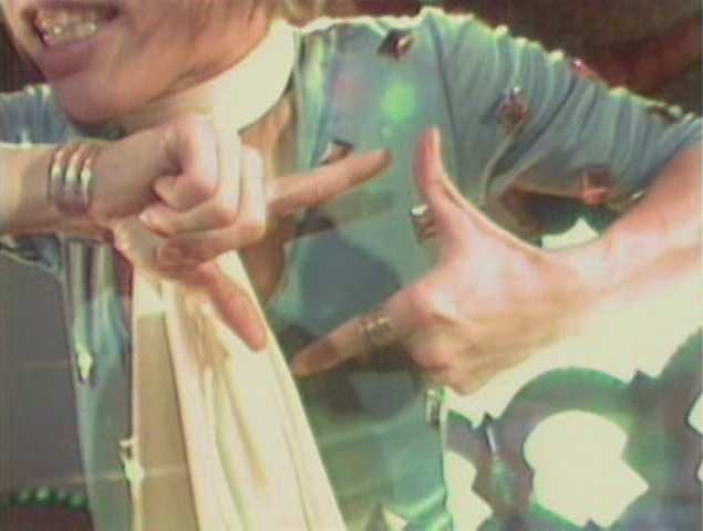A screenshot from T.M.Revolution's Aoi Hekireki music video where he's making a square shape with his fingers while singing the word 'shikaku'.